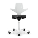 White ergonomic HAG Capisco Puls 8020 saddle chair with adjustable seat height and unique design.