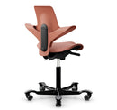 Ergonomic HAG Capisco Puls 8020 saddle chair in rosehip fabric with silver aluminum base and adjustable gas lift